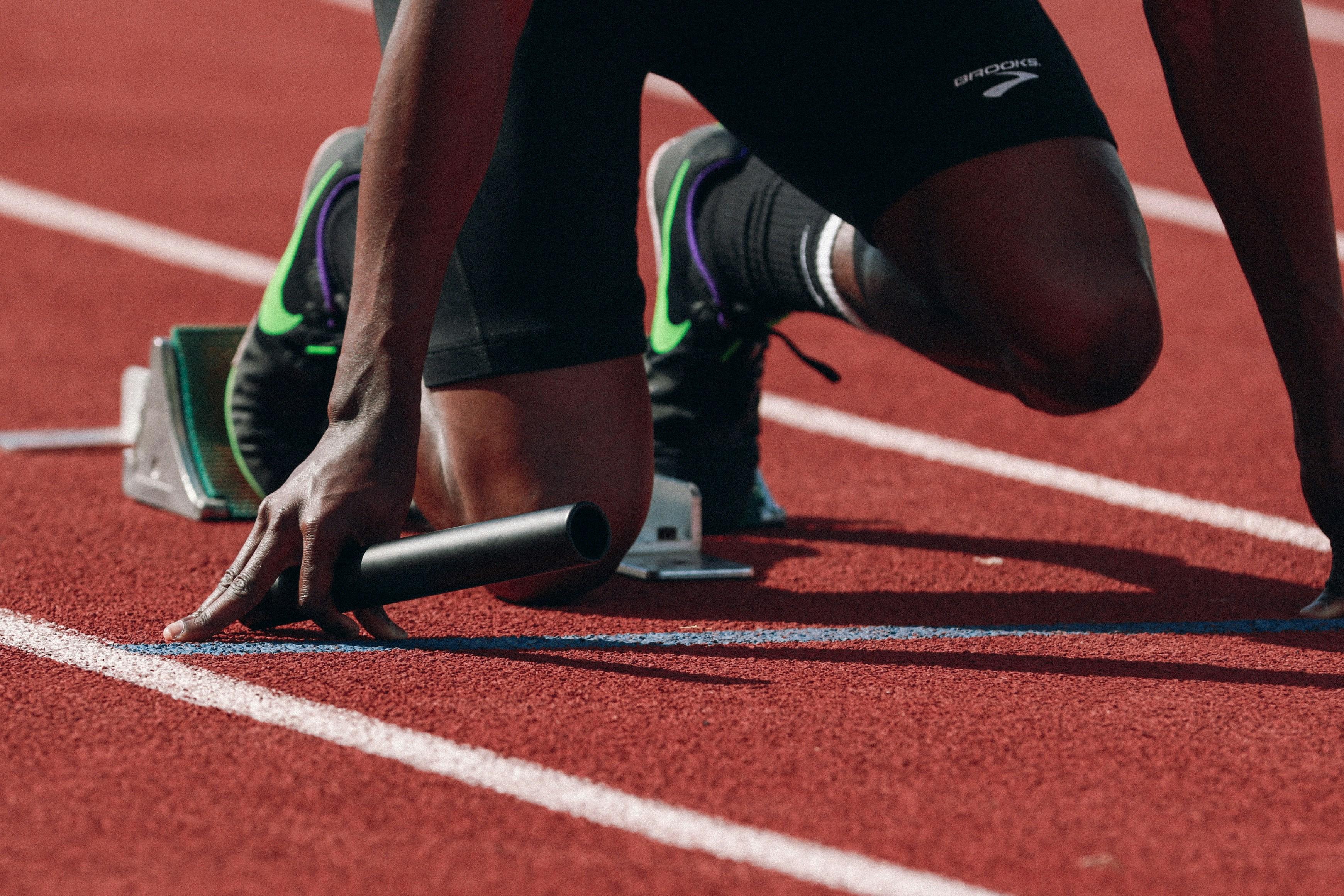 Sprinter in starting blocks on a track — speed and focus